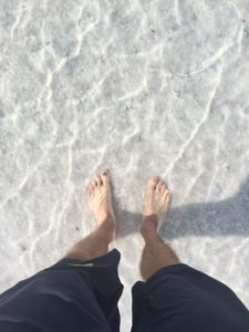 Coach Andrew Taylor dipping feet in the salt flats in Utah