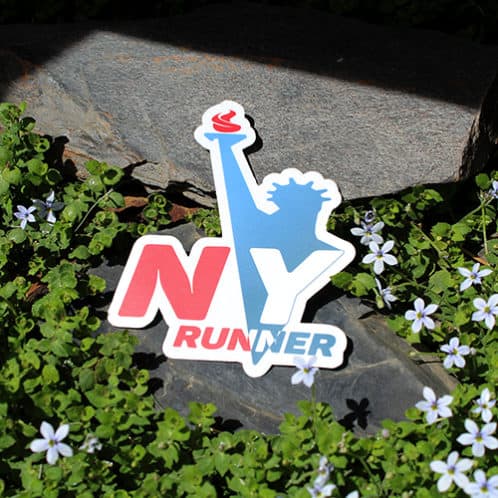 New York Running Sticker laying on rocks with white flowers for website