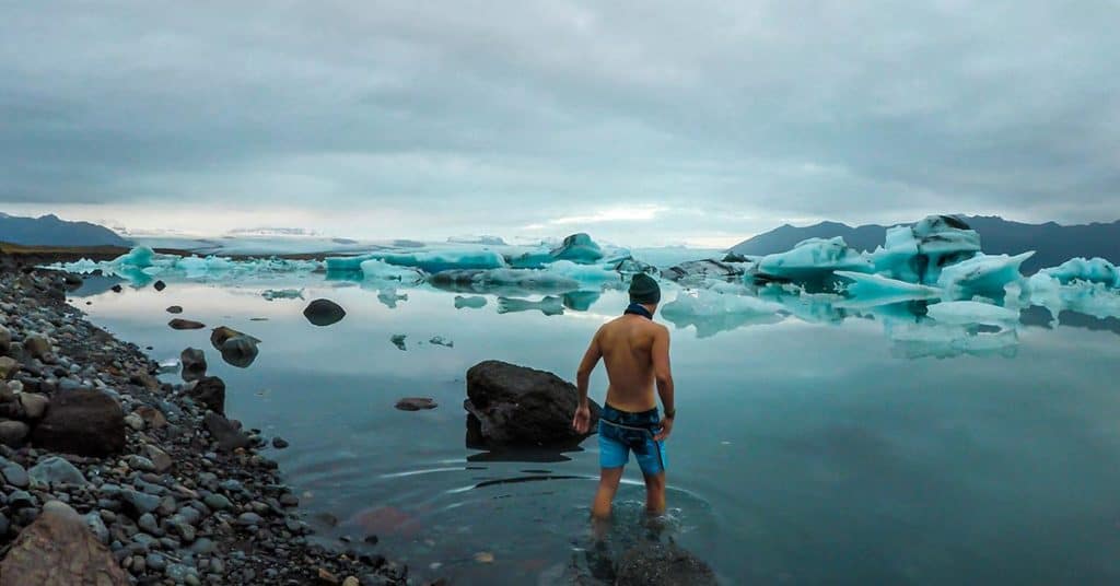 man icing after running in mountain lake
