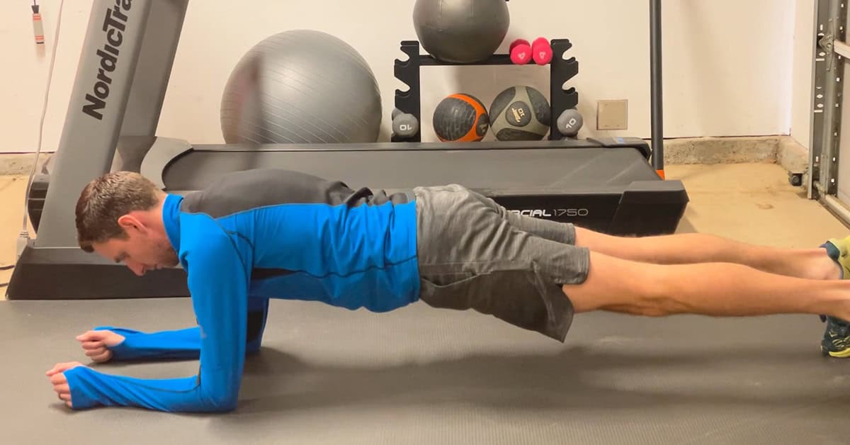 Runner demonstrating a forearm plank exercise to build core strength for running