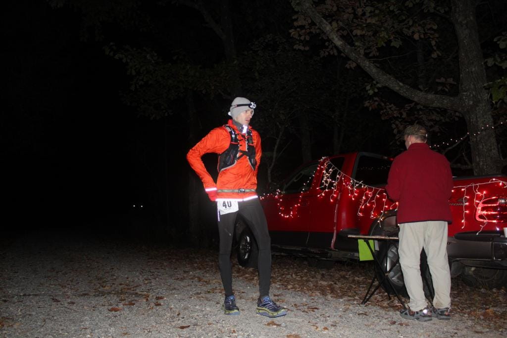 Coach Andrew Taylor stopping at an aid station at night during the Pinhoti 100