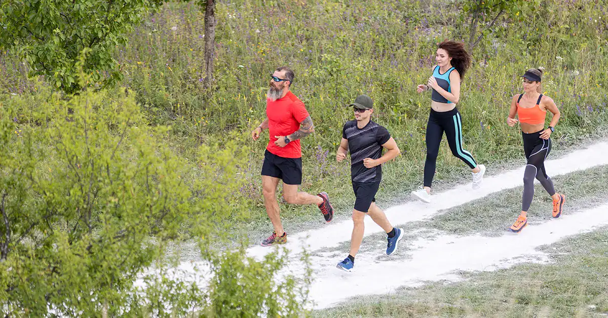 Group of runners doing an easy training run on a trail path during a marathon taper